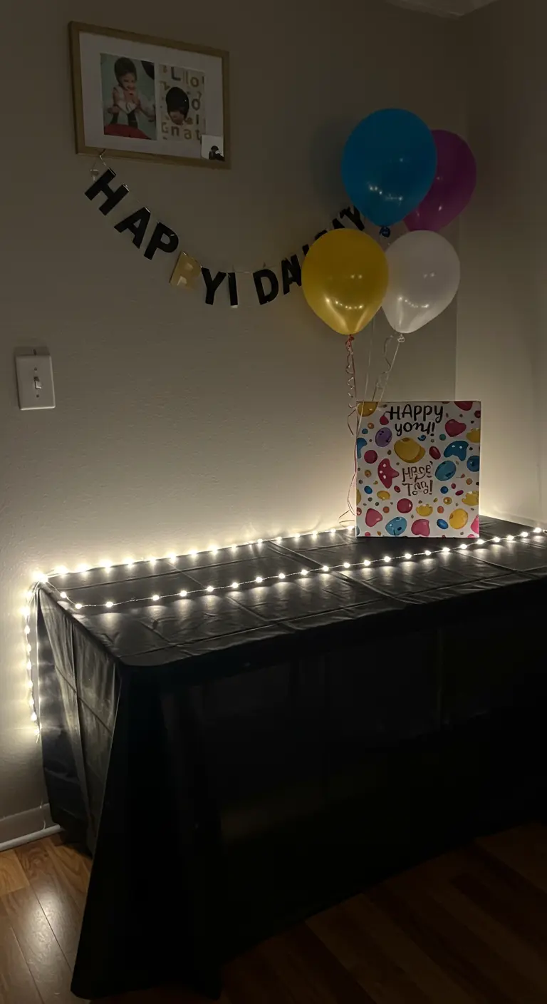 A black-clothed buffet table illuminated from behind with a strip of cool white LED lights.