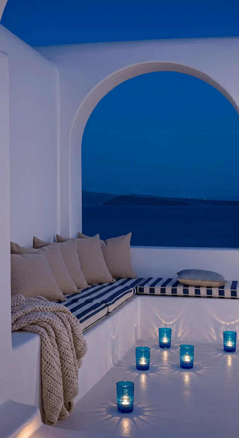 A whitewashed balcony with a built-in bench, accented with blue tea light holders.