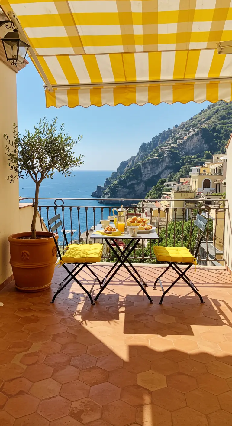 Balcony breakfast with a yellow striped awning and cushions overlooking the Italian coast.