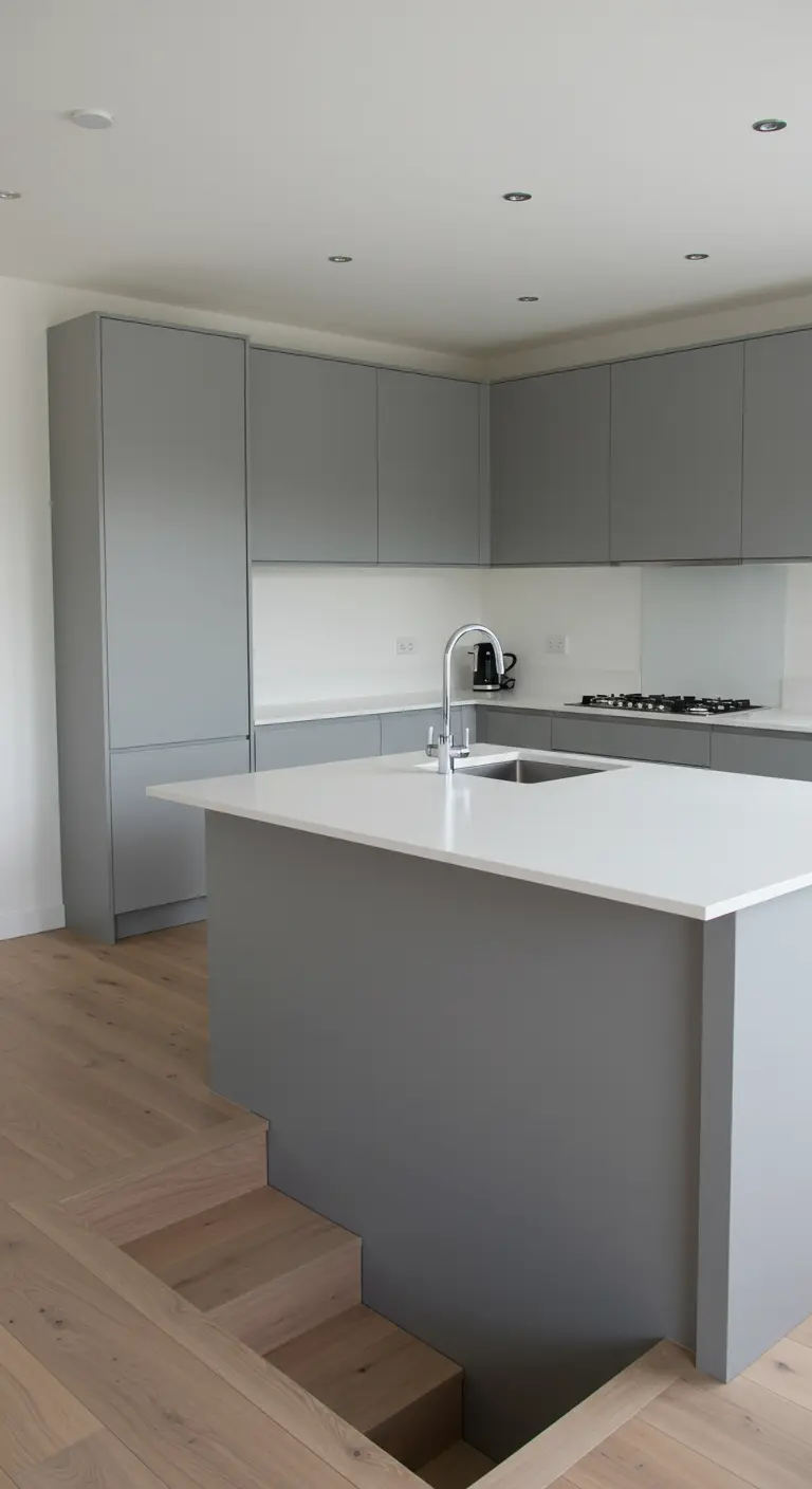 A grey kitchen island with steps leading down into a sunken area behind it.