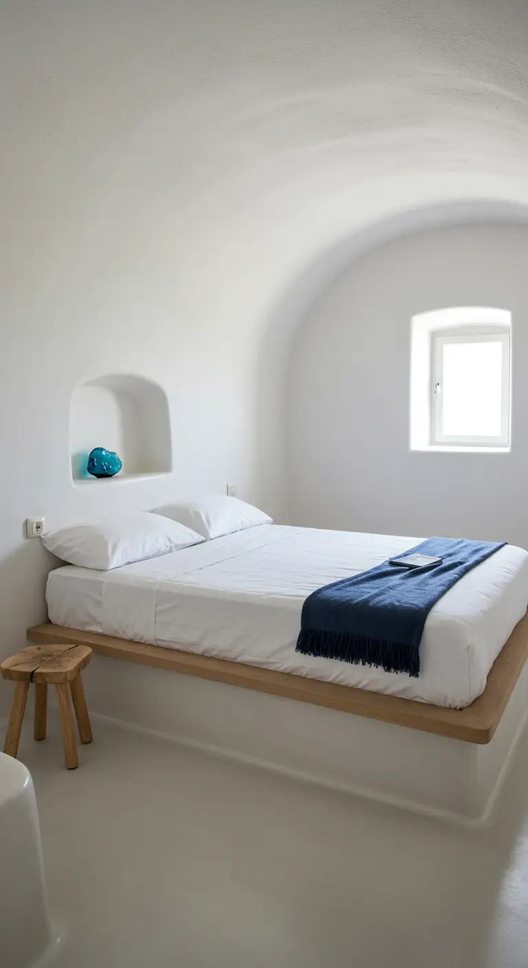 Minimalist white bedroom with a floating bed platform and an arched wall niche.