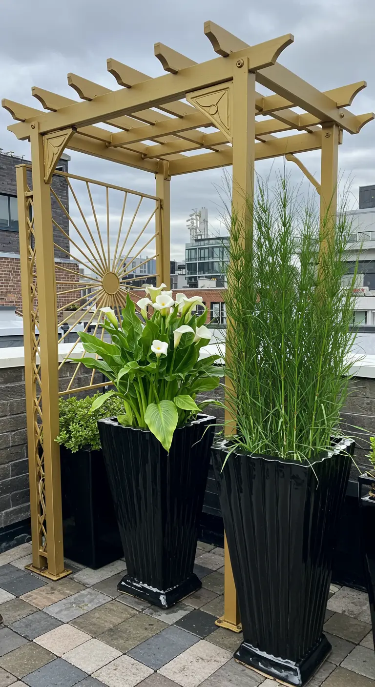 Gold-painted Art Deco style pergola on a rooftop with tall black planters holding Calla Lilies.