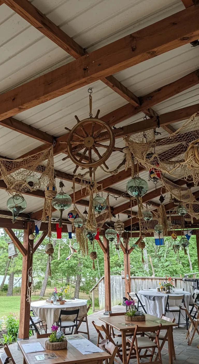 Covered patio ceiling decorated with a ship's wheel, nets, and hanging glass floats.
