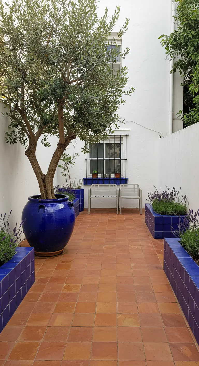 Courtyard with terracotta tiles and built-in planters faced with blue tiles.