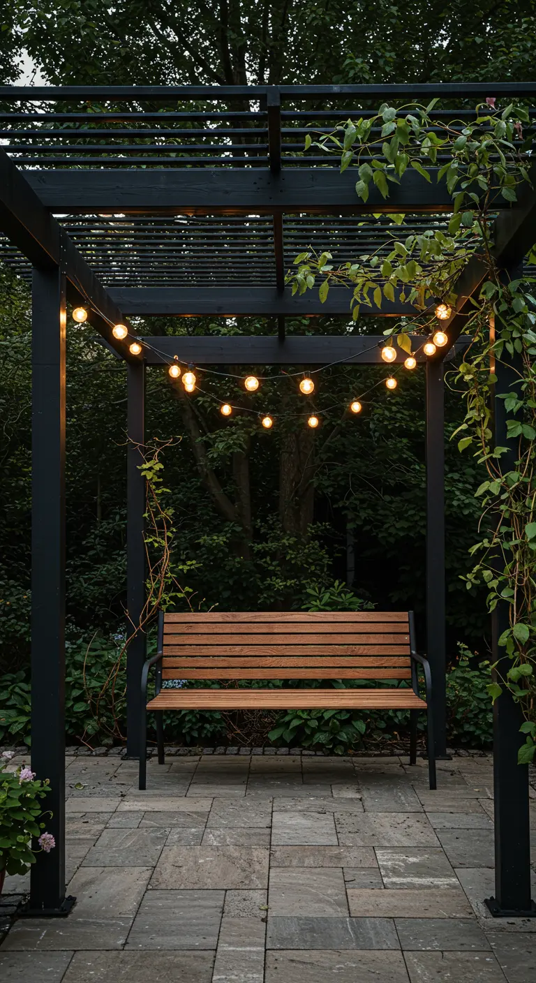 A black pergola frames a single bench, with string lights and climbing vines.