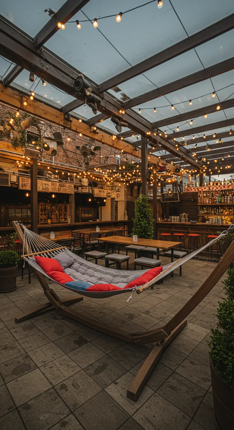 A large hammock on a stand in the middle of a bustling rooftop bar with extensive string lights.