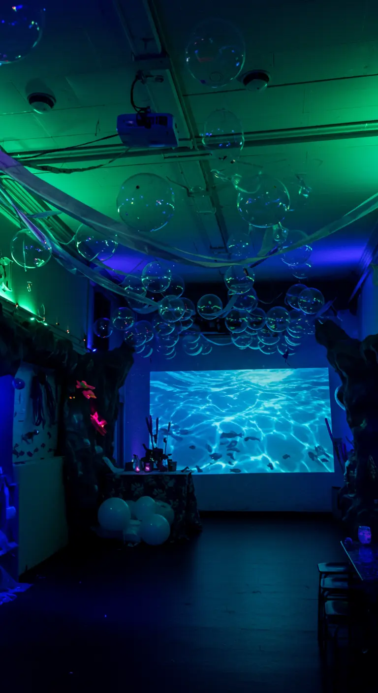 A dark room with blue and green lighting, filled with clear balloons that look like bubbles.