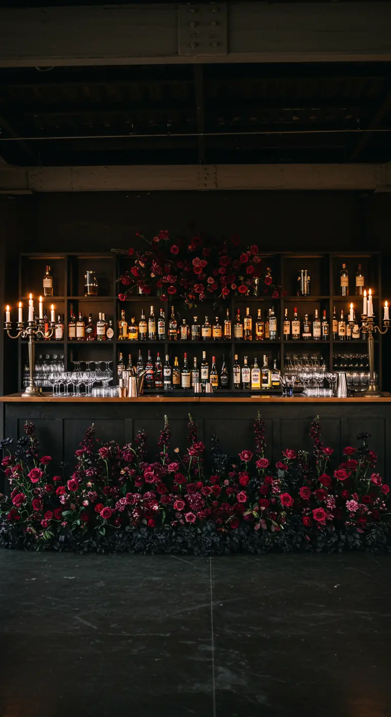 A dark wood bar with its entire front base lined with a thick arrangement of burgundy flowers.